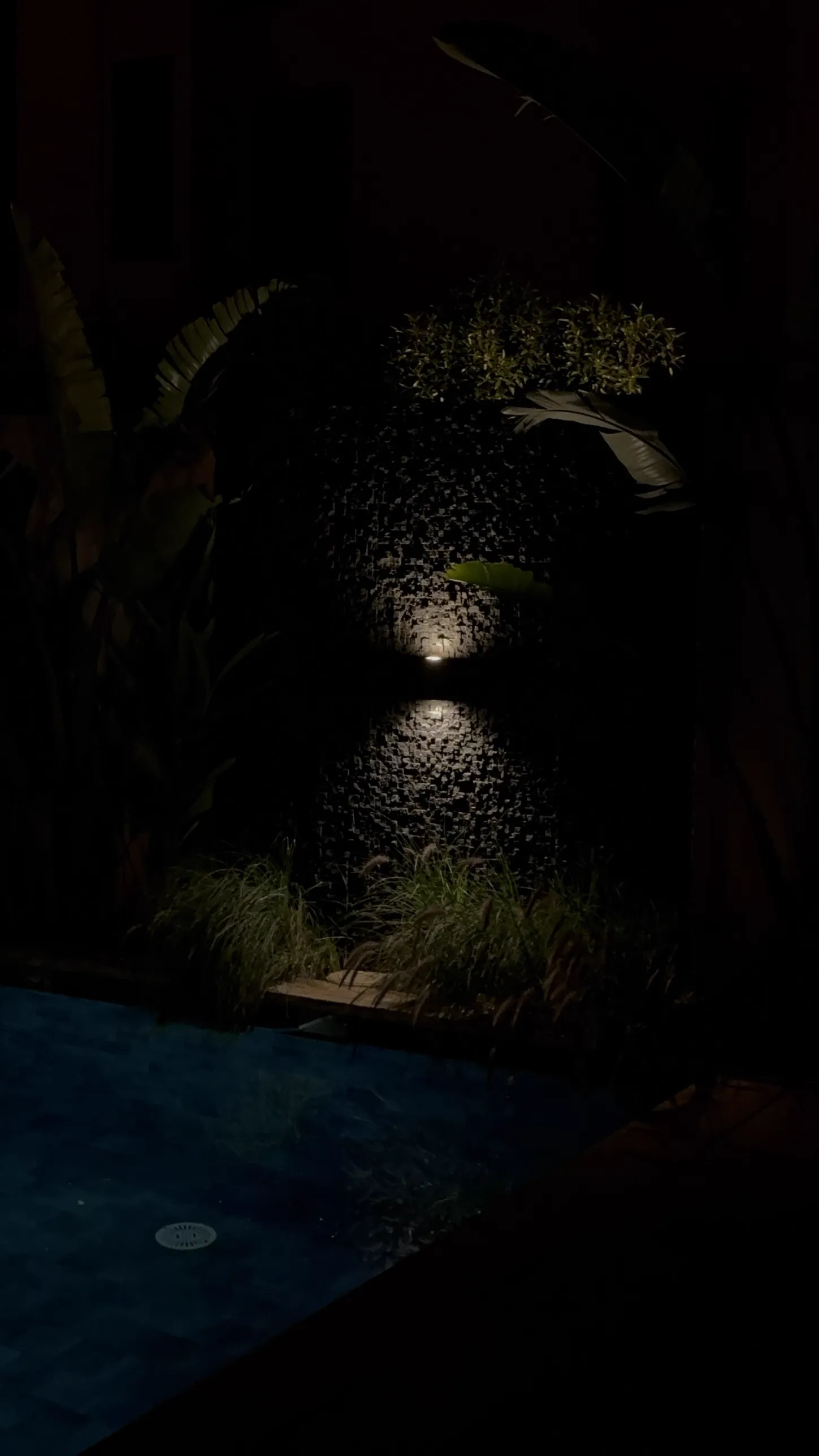 Mur de jardin en relief Le Celestone éclairé la nuit, au bord de la piscine