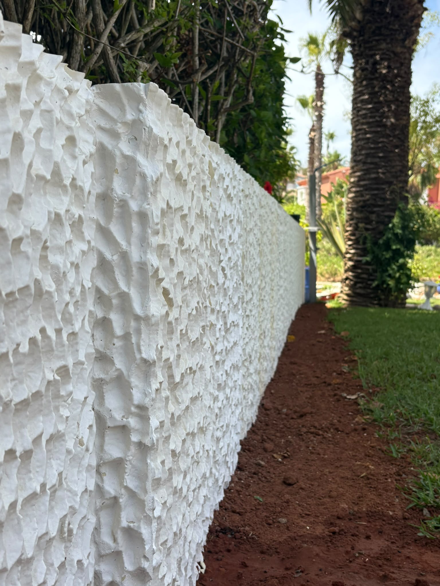 Moon 1 — mur d'enceinte en perspective, jardin aux palmiers