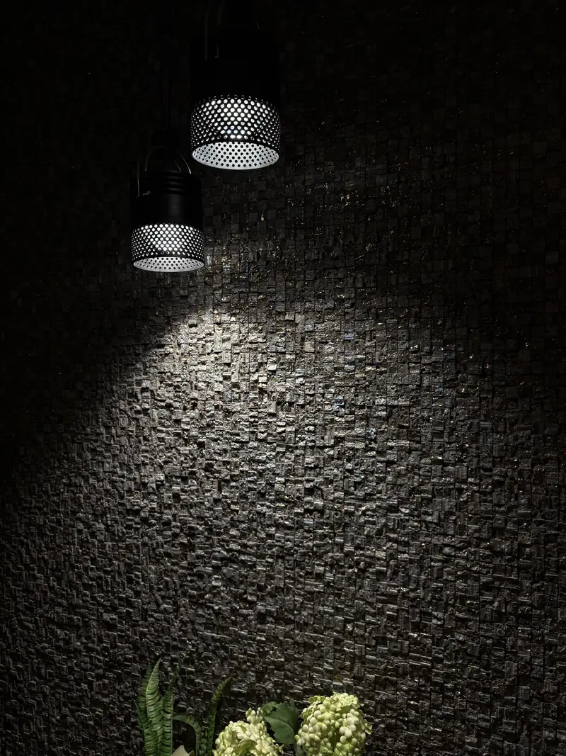 Mur en relief sous un éclairage rasant, dans un intérieur professionnel